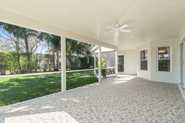 unfurnished sunroom featuring ceiling fan