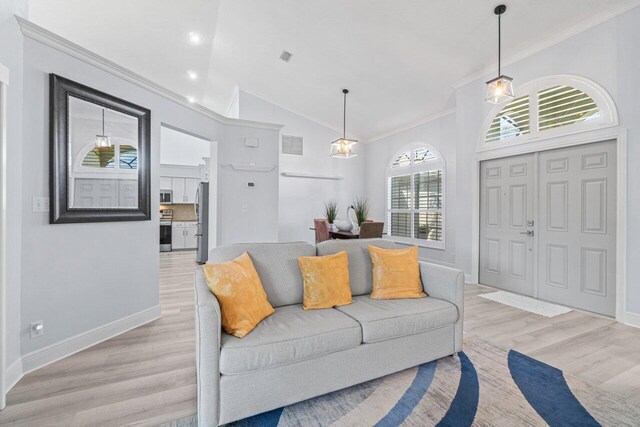 dining space with an inviting chandelier, ornamental molding, and light hardwood / wood-style floors