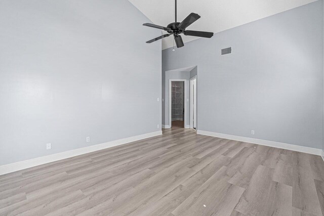 living room with crown molding, high vaulted ceiling, and light hardwood / wood-style flooring