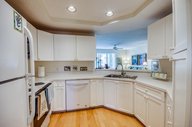 kitchen featuring white cabinetry, white appliances, sink, and light hardwood / wood-style flooring