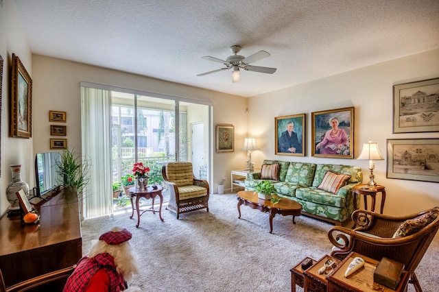 carpeted living room with ceiling fan and a textured ceiling