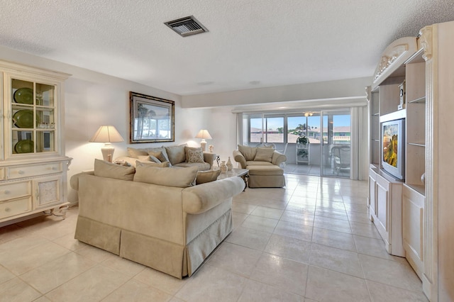 tiled living room featuring a textured ceiling