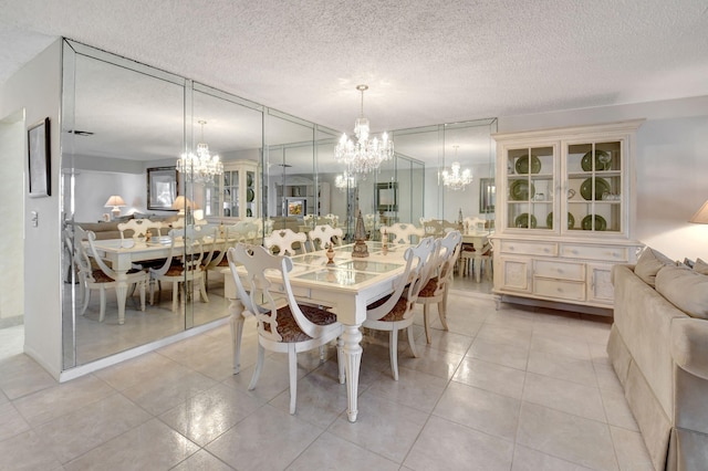 dining space with light tile patterned floors, a notable chandelier, and a textured ceiling