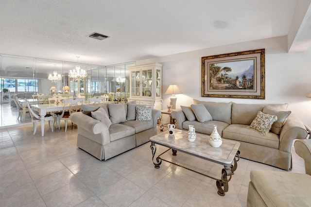 living room featuring light tile patterned flooring, a chandelier, and a textured ceiling