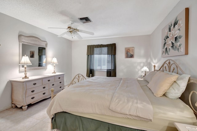 bedroom featuring ceiling fan, a textured ceiling, and light tile patterned floors