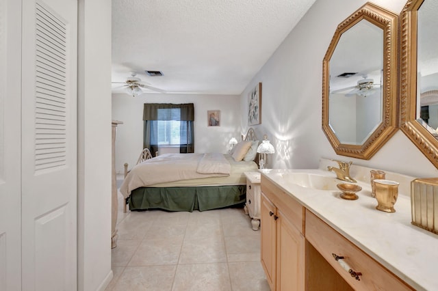 tiled bedroom featuring ceiling fan, sink, and a textured ceiling