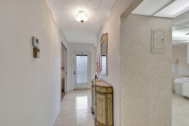 hallway featuring light tile patterned floors, electric panel, and a textured ceiling