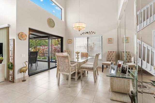 dining room with light tile patterned floors, a towering ceiling, and a chandelier