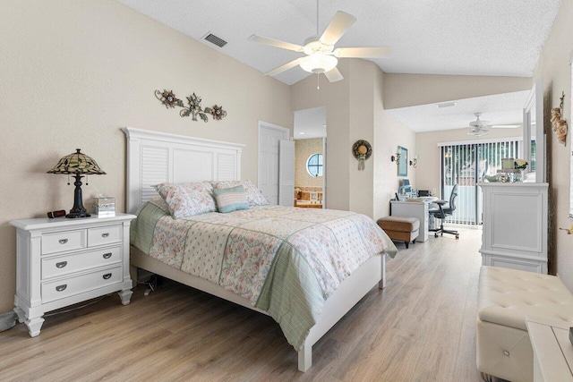 bedroom featuring vaulted ceiling, ceiling fan, a textured ceiling, ensuite bath, and light hardwood / wood-style flooring