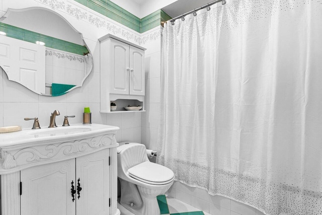 full bathroom with shower / tub combo with curtain, tile walls, vanity, tile patterned floors, and toilet