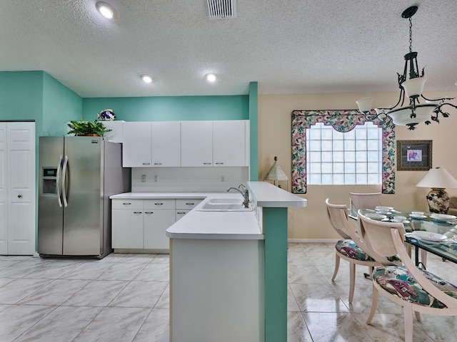 kitchen with sink, white cabinetry, stainless steel fridge with ice dispenser, hanging light fixtures, and kitchen peninsula