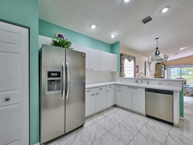 kitchen with pendant lighting, stainless steel appliances, sink, and white cabinets