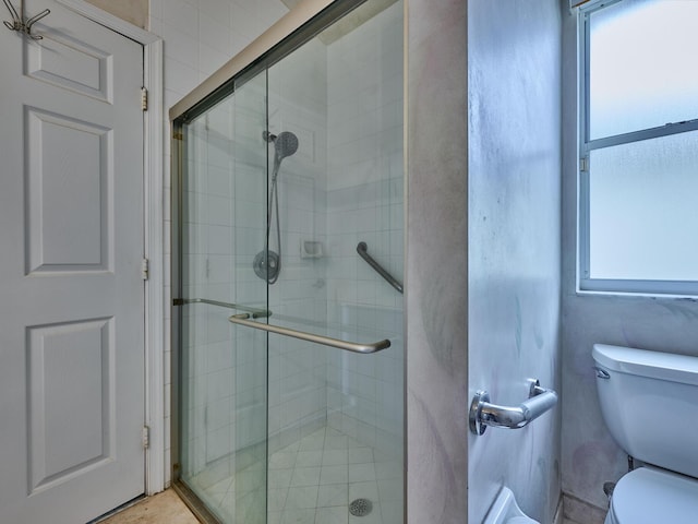 bathroom featuring walk in shower and toilet