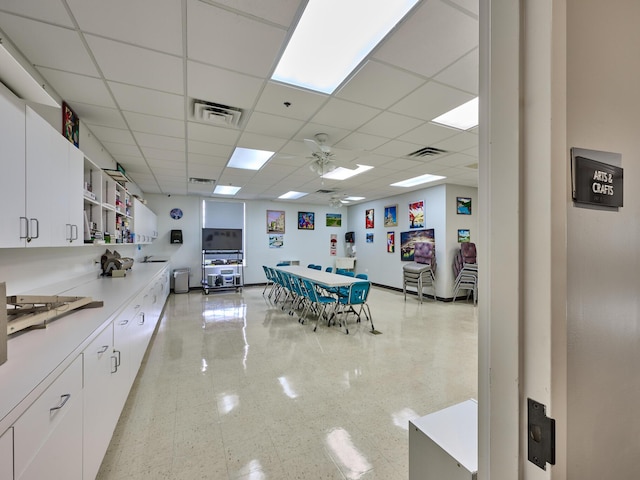 interior space featuring white cabinetry, a paneled ceiling, and ceiling fan