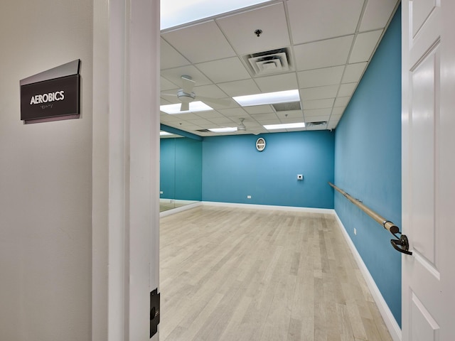 empty room featuring a drop ceiling and light hardwood / wood-style floors