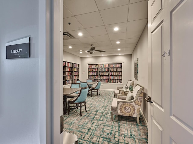 living area featuring carpet floors and ceiling fan