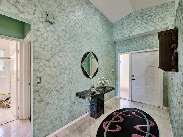 entrance foyer featuring light tile patterned flooring, vaulted ceiling, and a textured ceiling