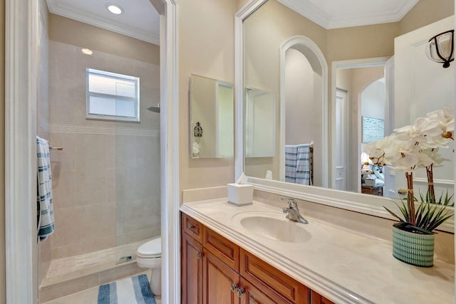 bathroom featuring vanity, crown molding, toilet, and tiled shower