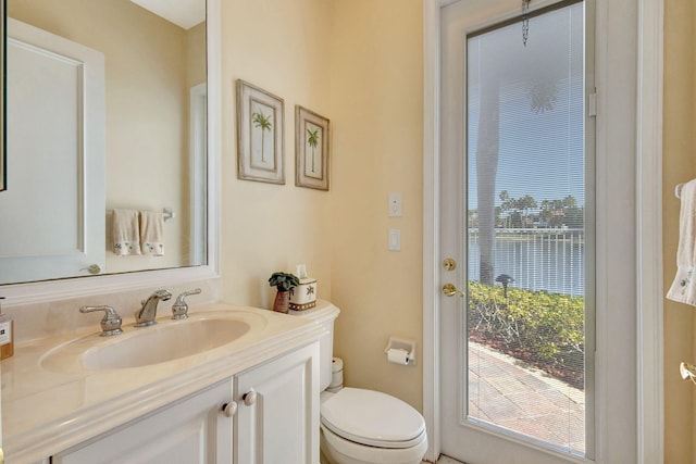 bathroom featuring a water view, vanity, and toilet