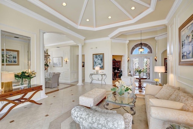 living room with light tile patterned floors, a towering ceiling, ornamental molding, and ornate columns