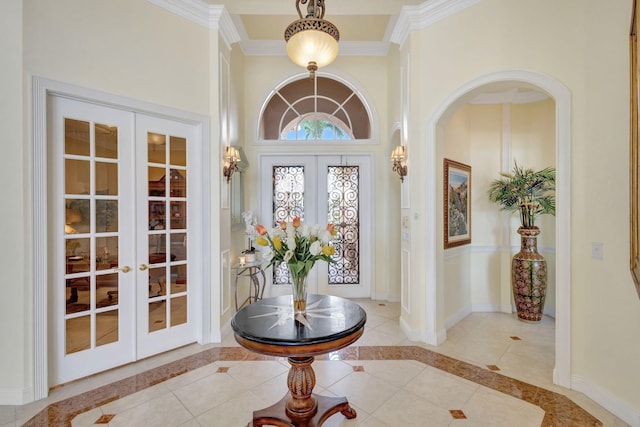 entrance foyer featuring french doors, crown molding, and light tile patterned floors