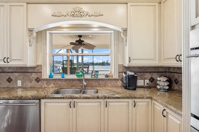 kitchen featuring arched walkways, dishwasher, backsplash, and a sink