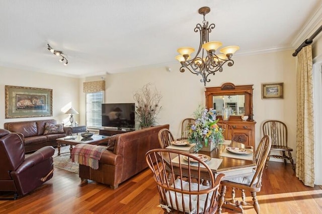 dining room featuring a notable chandelier, crown molding, and wood finished floors