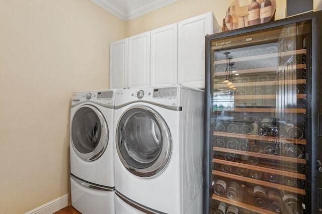 clothes washing area with cabinet space, baseboards, ornamental molding, and separate washer and dryer