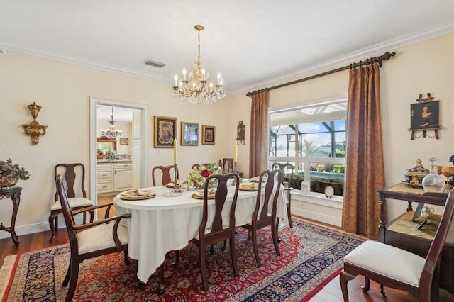 dining area with crown molding, wood finished floors, visible vents, baseboards, and an inviting chandelier