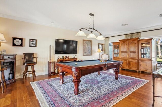 dining space featuring ornamental molding, wood-type flooring, and a chandelier