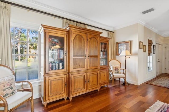 living area featuring dark wood-style floors, ornamental molding, visible vents, and baseboards