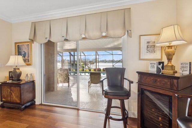 entryway with a sunroom, ornamental molding, and wood finished floors