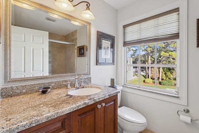 full bathroom with toilet, vanity, a shower stall, and visible vents