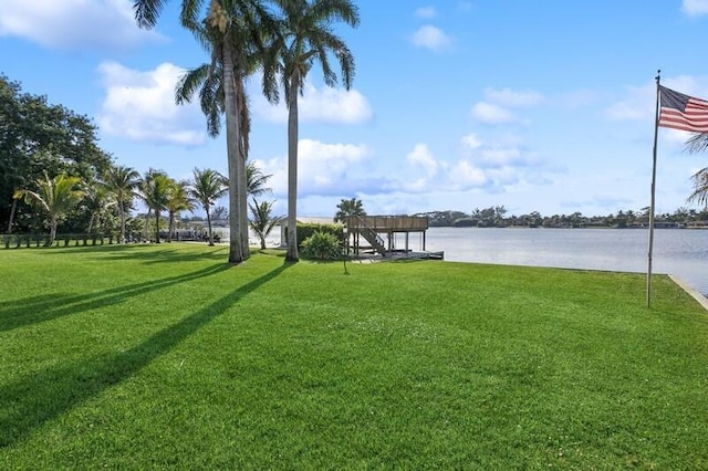 dock area featuring a lawn and a water view