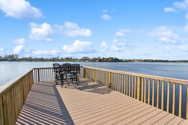 view of dock with a yard and a water view