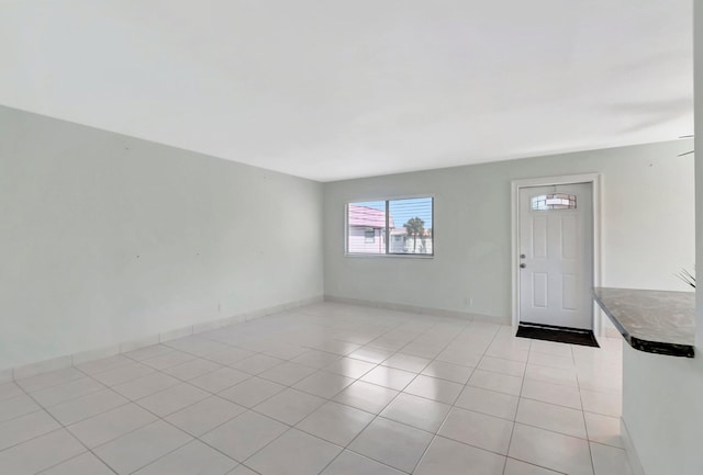 interior space with light tile patterned flooring and baseboards