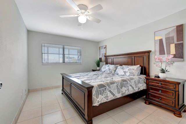 bedroom featuring baseboards, light tile patterned flooring, and a ceiling fan