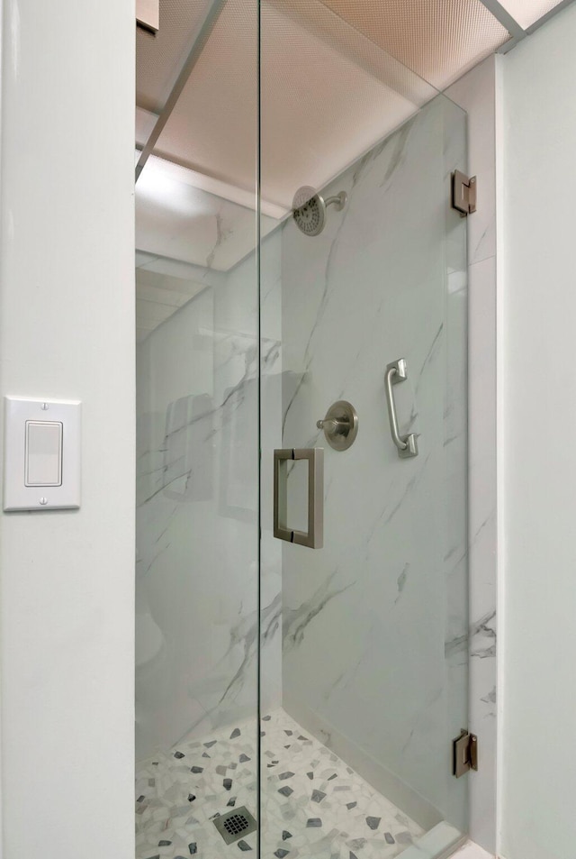 bathroom featuring a marble finish shower
