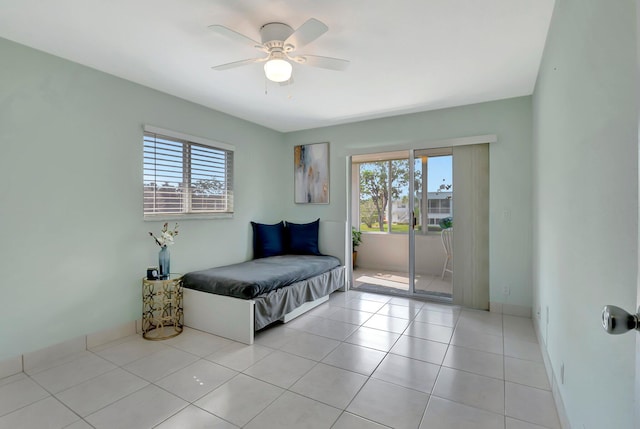 bedroom with light tile patterned floors, multiple windows, access to exterior, and a ceiling fan