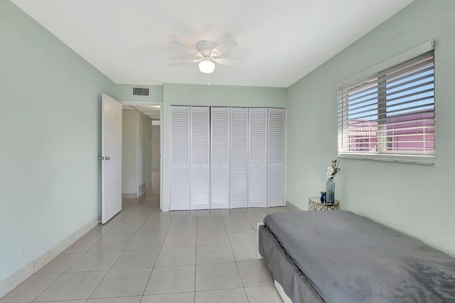 unfurnished bedroom featuring light tile patterned floors, visible vents, a closet, and a ceiling fan
