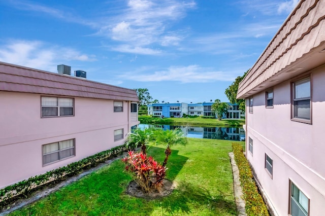 view of yard with a water view and central AC unit