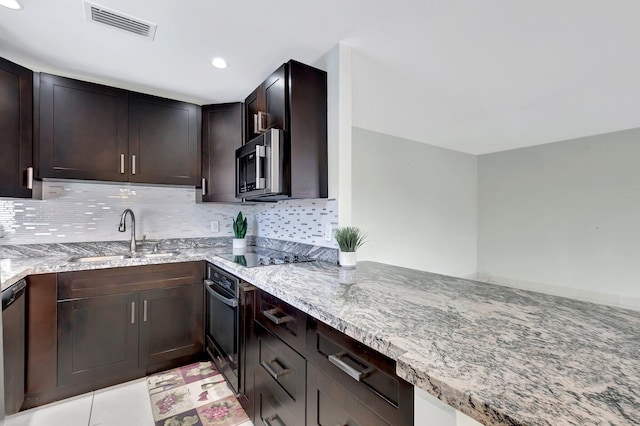 kitchen featuring light stone counters, sink, dark brown cabinets, and black appliances