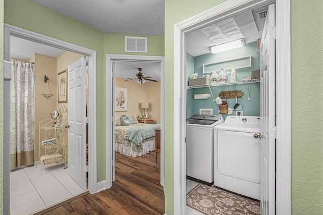 laundry area with washing machine and dryer, hardwood / wood-style floors, ceiling fan, and a textured ceiling