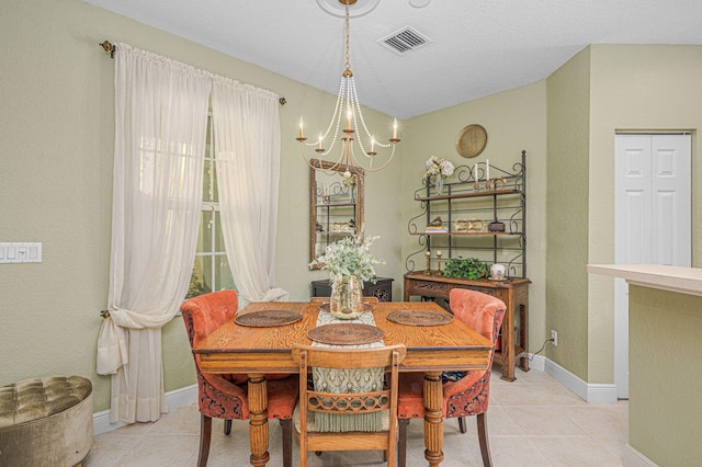 tiled dining room with a chandelier