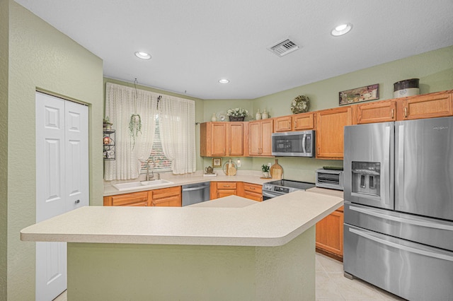 kitchen featuring sink, light tile patterned floors, stainless steel appliances, and a kitchen island