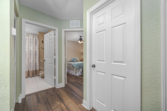 hall with dark hardwood / wood-style flooring and a textured ceiling