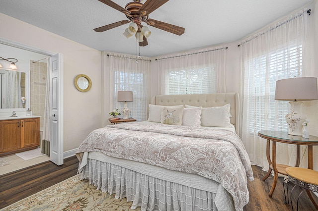 bedroom with dark hardwood / wood-style flooring, sink, a textured ceiling, and ensuite bathroom