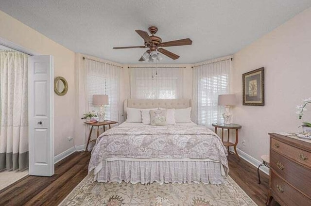 bedroom with ceiling fan, dark hardwood / wood-style flooring, and a textured ceiling