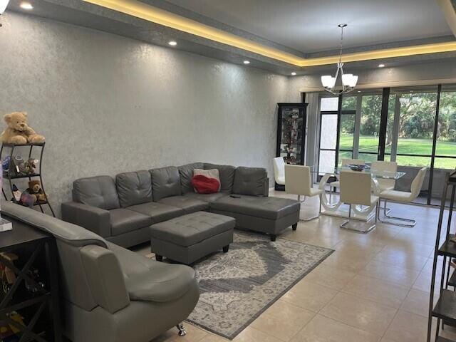 living room with a raised ceiling and an inviting chandelier