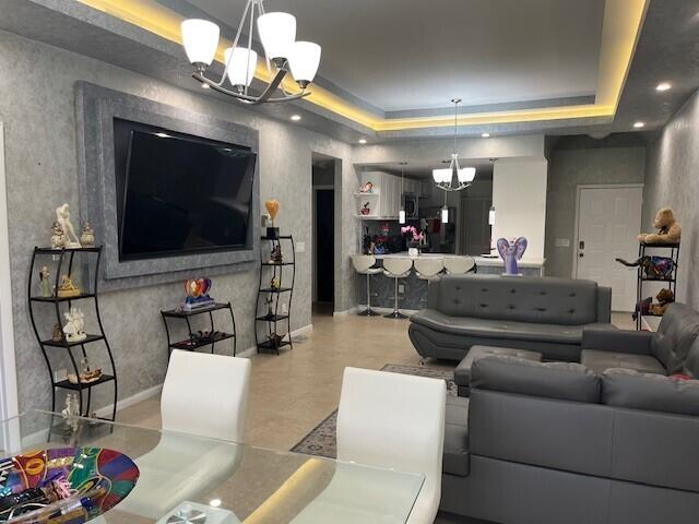 living room featuring an inviting chandelier and a raised ceiling